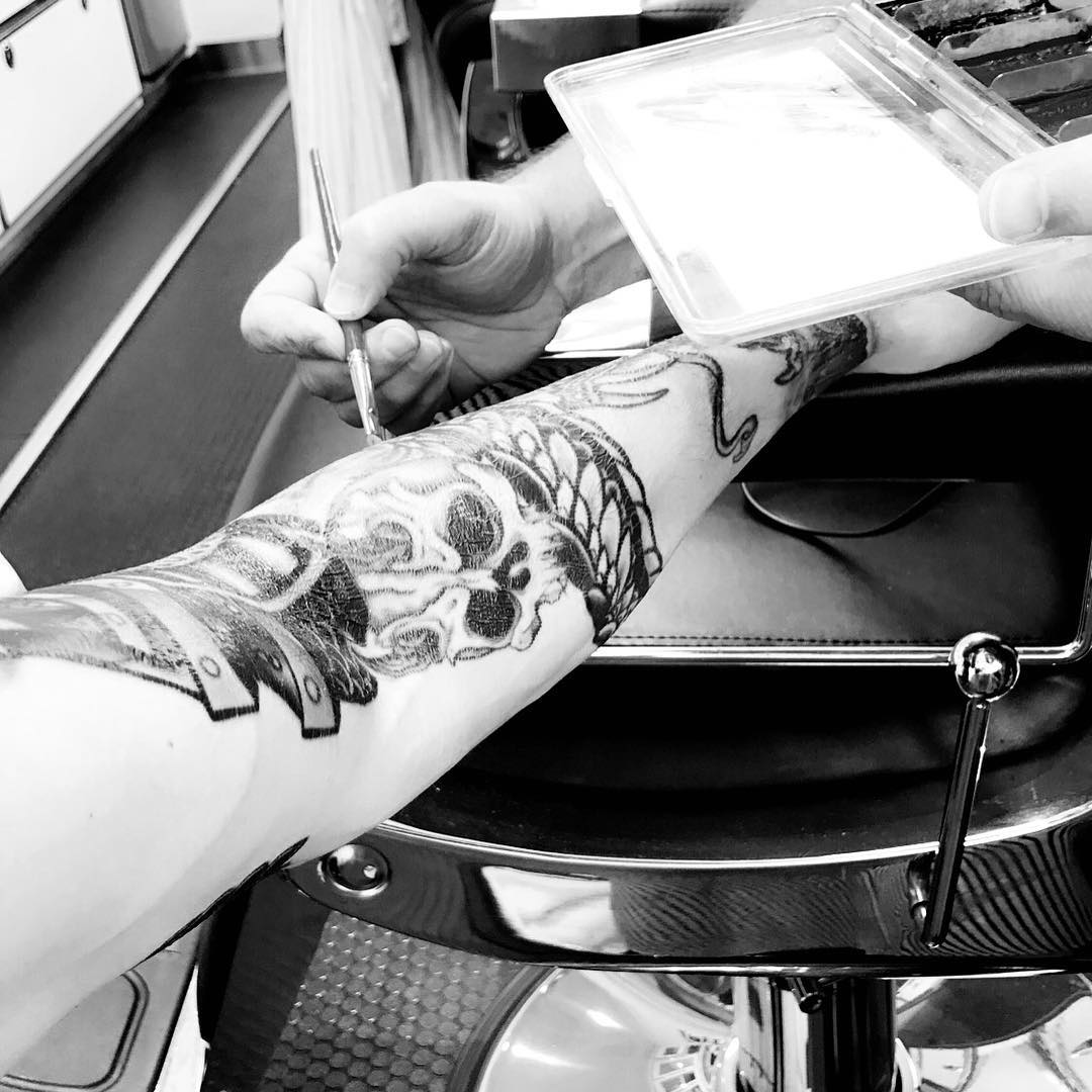 Photo du tournage du film Avengers: Endgame avec le bras de Jeremy Renner en train d'être tatoué
